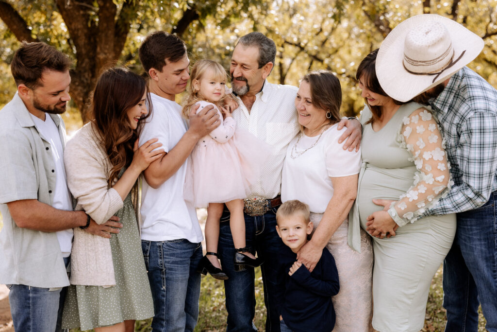 family looking at each other with trees in the background