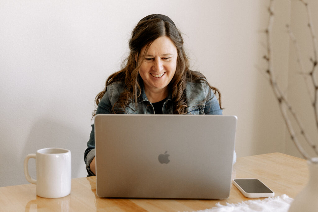 photographer sitting by a table looking at her laptop