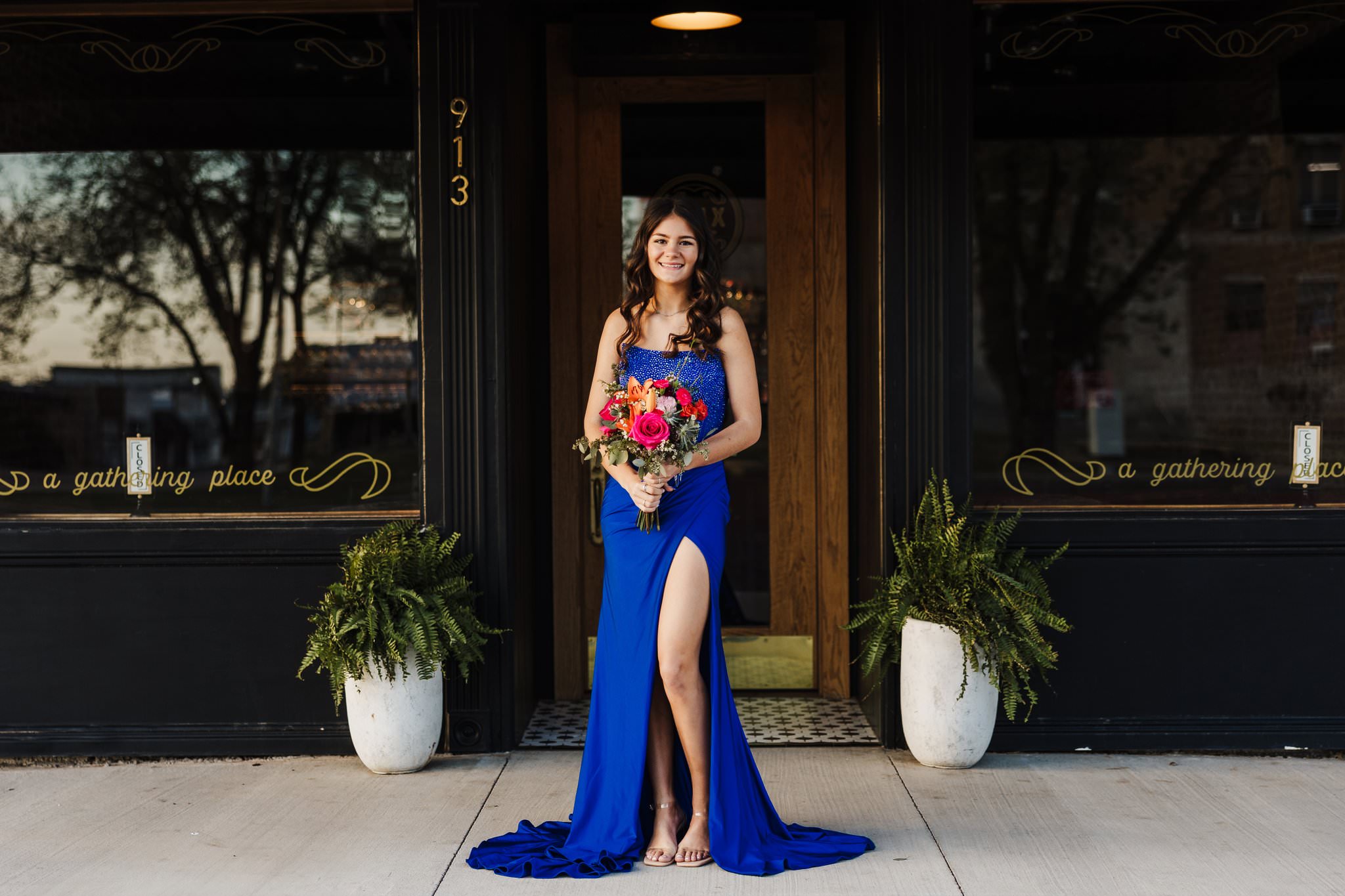 high school prom mini session photo captured with senior in a royal blue prom dress with a bouquet of florals in hand.