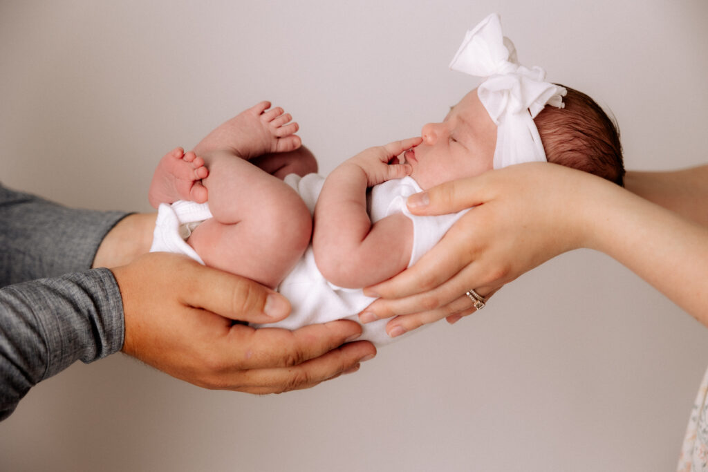 Mom and Dad Holding Baby in Denver City Newborn Photographer Studio