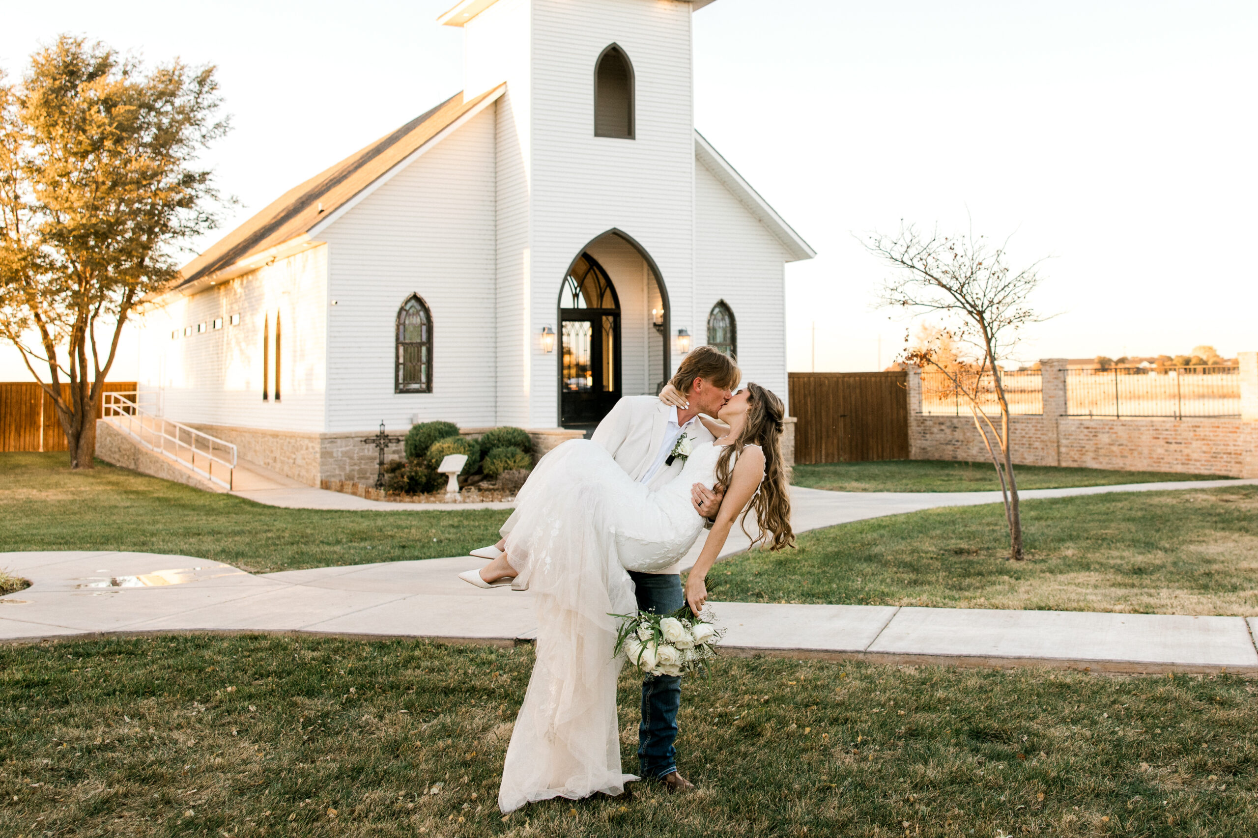 Mary Wiebe photography shot a stunning Eberly Brooks Wedding in November. Couple is kissing in front of the chapel in Lubbock Texas.