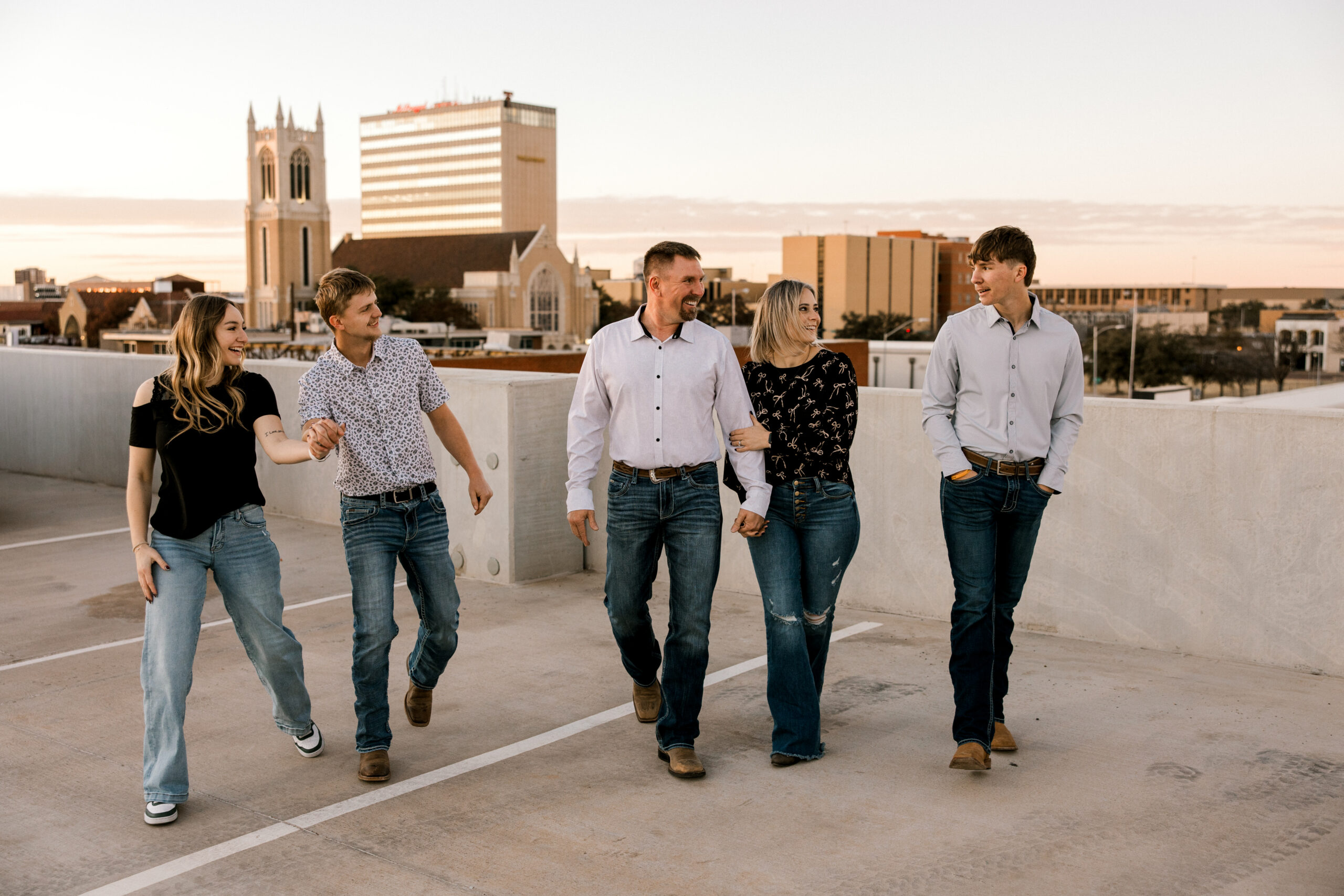 One of the best family portrait locations in Lubbock, Texas is the rooftop on Citizen Tower on Avenue K, which is where this photo was taken. Mary Wiebe captured this family of 5 running on the rooftop laughing and smiling.