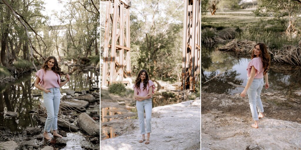 With a river and river bank in the background, a senior girl is walking away from the photographer while looking back. Captured by Lubbock senior photographer, Mary Wiebe. 