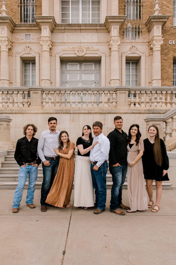 Family portraits taken at Texas Tech by Mary Wiebe Photography. Family members standing in a line holding each other.  