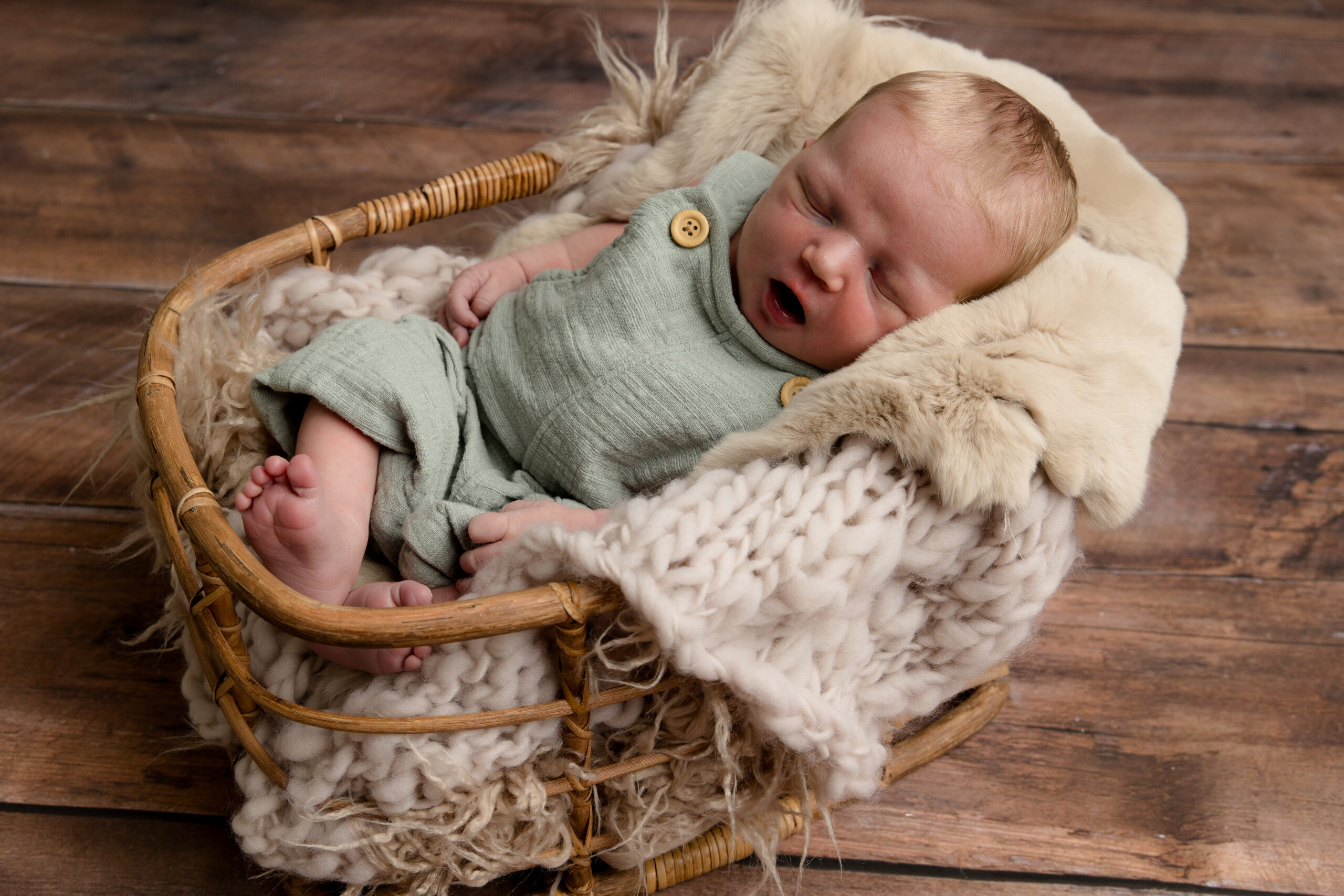 Lubbock newborn photographer, Mary Wiebe, captured this newborn boy laying in a basket with blankets overflowing.