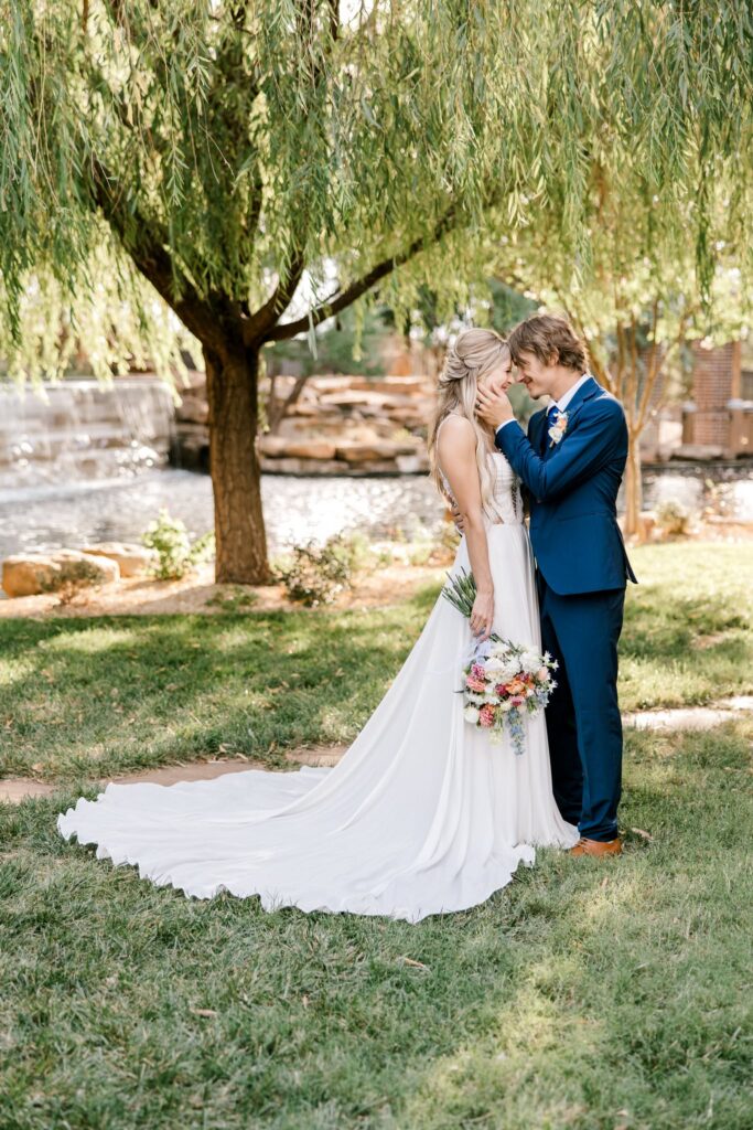 Bride and groom at the wedding venue, The Willows. Standing looking at each other.