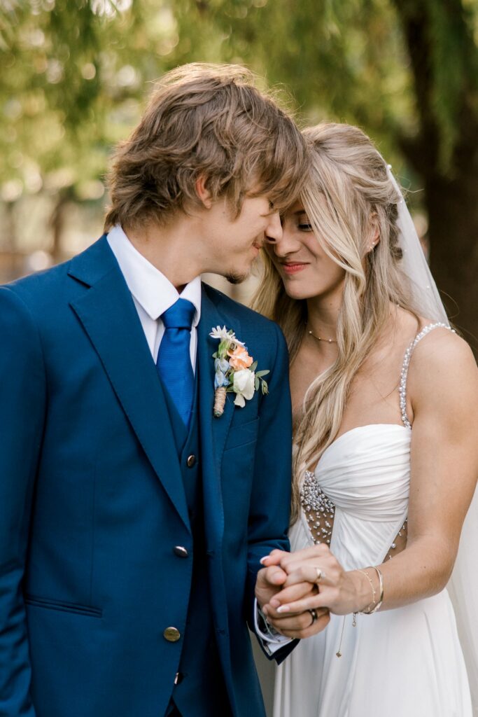 Close up image of the groom holding the brides hand