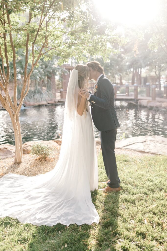 Hazy image of the bride and groom kissing at the pond at the Willows event center