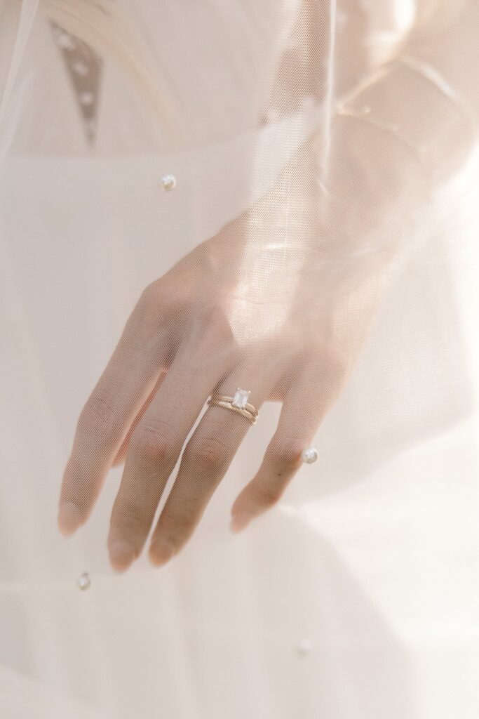 Detail shot of the brides wedding ring through the veil