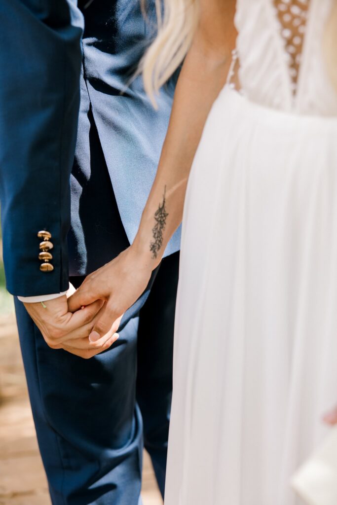 Detail photo of the bride holding the grooms hand.