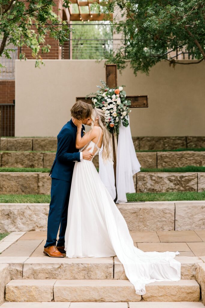 Bride and groom kissing at the altar