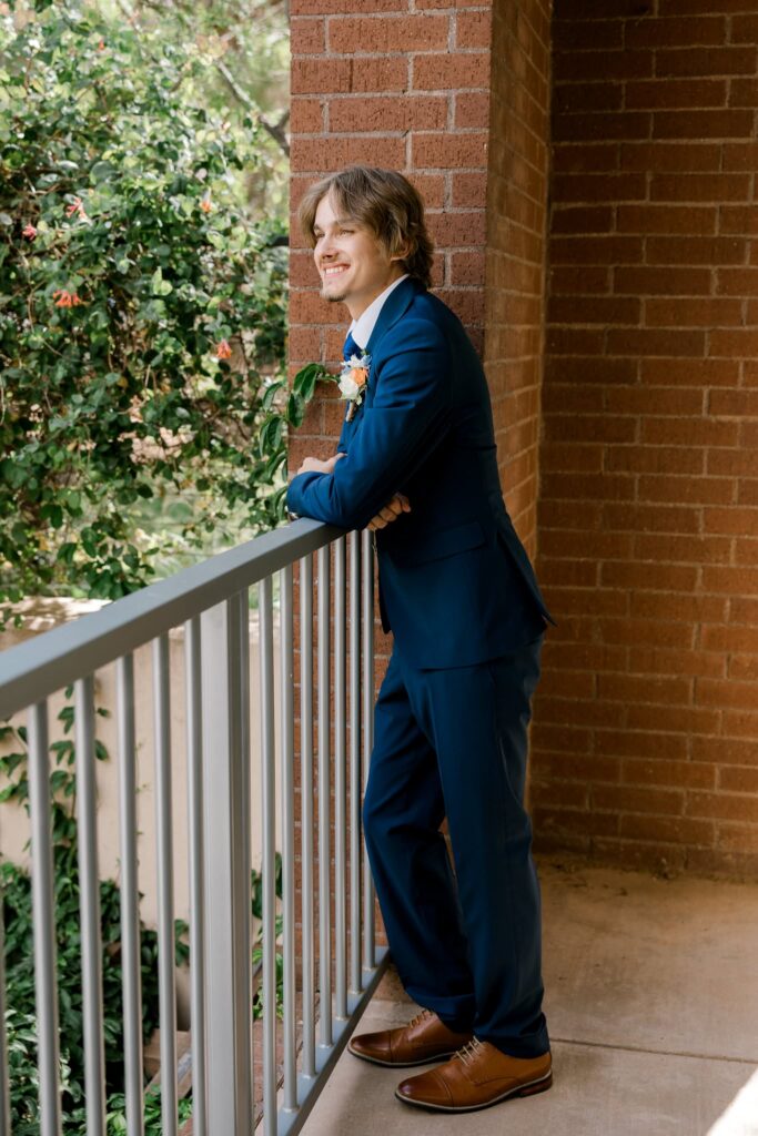 Groom looking off into the distance, smiling. Photo captured at the wedding venue, the Willows