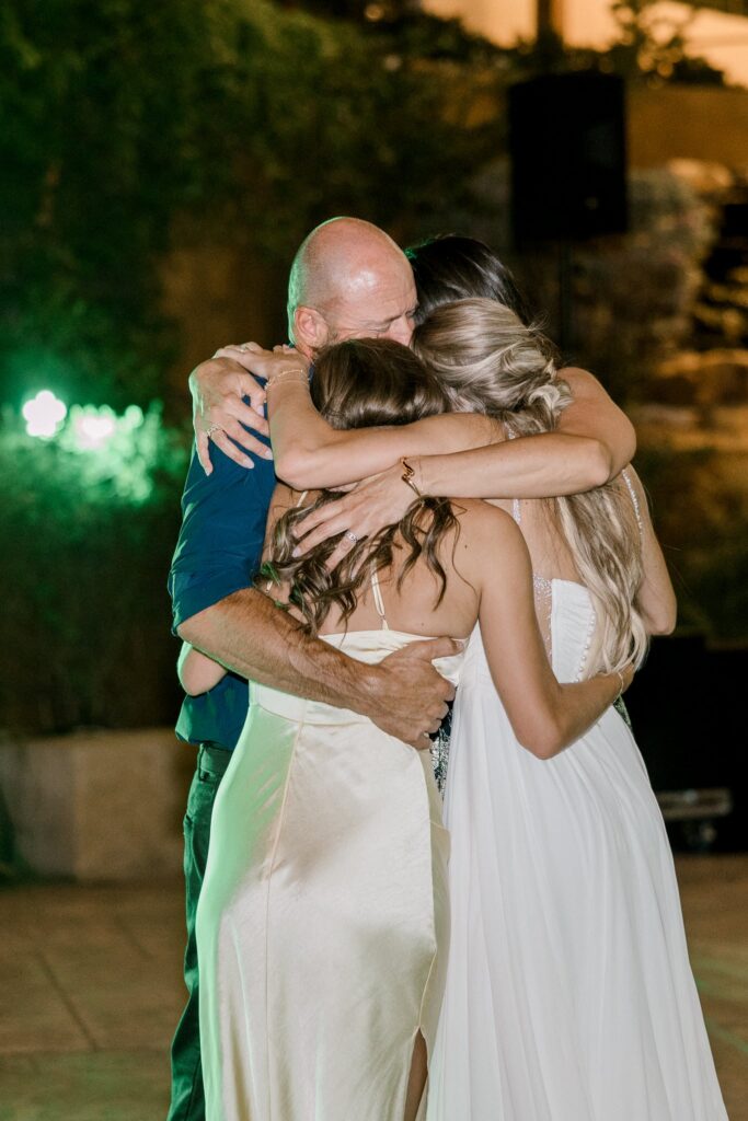 Bride, her sister, and her dad hugging at the end of the evening, very emotional moment.