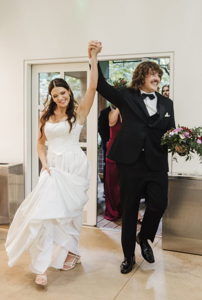 Bride and groom walking into reception area, cheering as they come in the dooor.