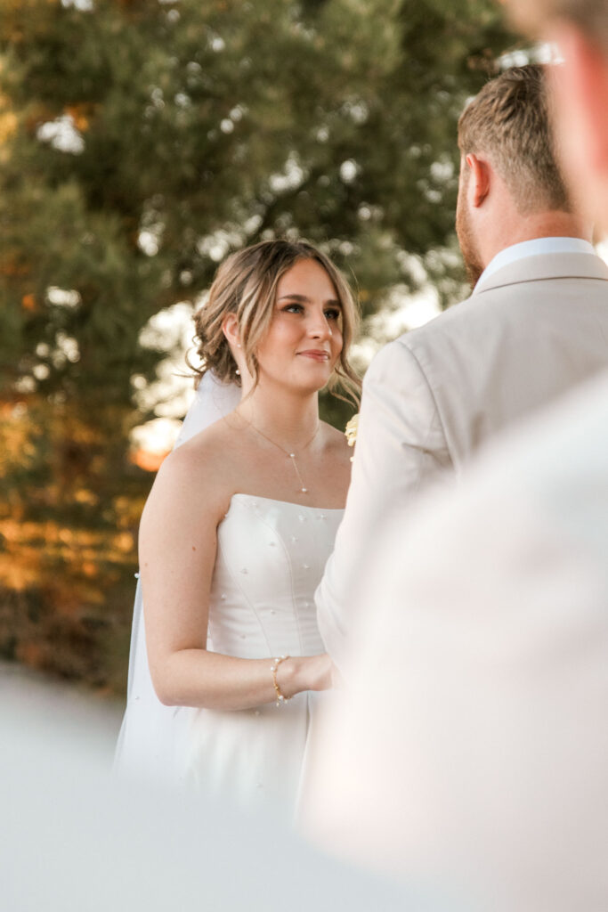 Bride smiling at groom during ceremony