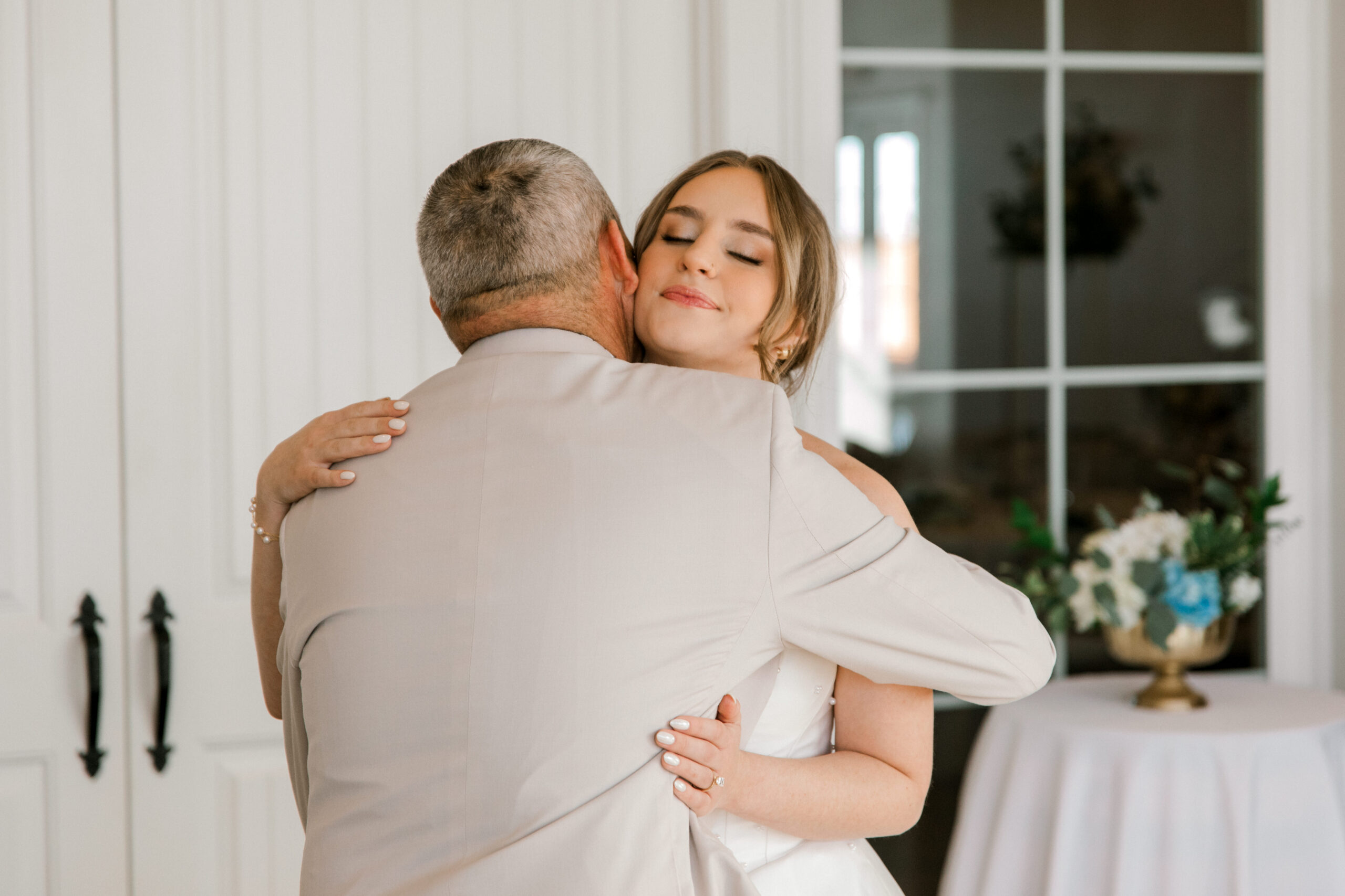 bride and her dad are hugging during first look