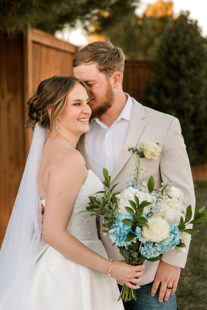Groom kissing brides temple during portraits