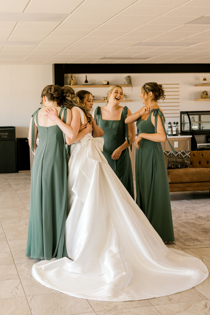 Bride hugging the bridesmaids after first look.