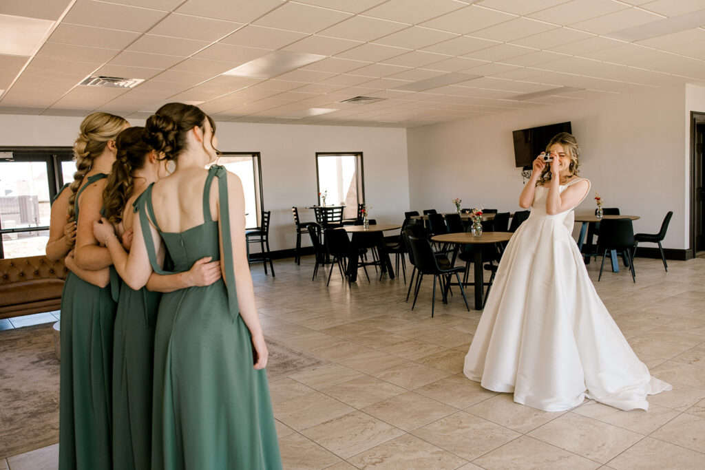 Bride snapping a photo of the bridesmaids with her film camera.