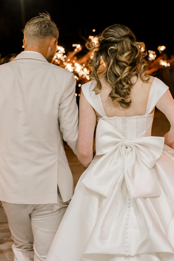 Portrait of the brides dress focused on the big bow on the back of the dress.