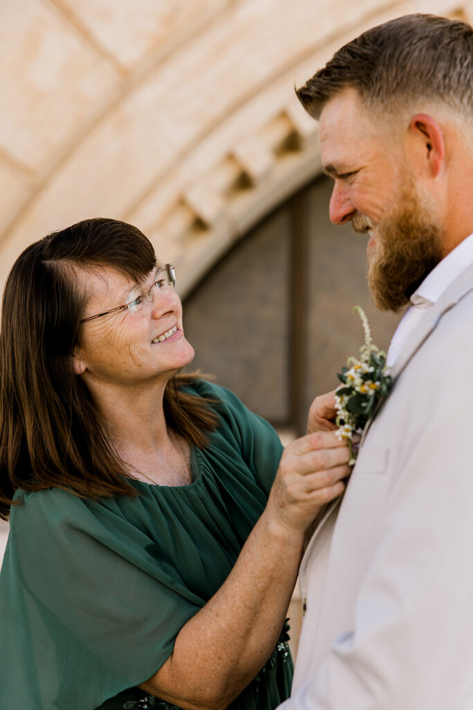 Mother of the groom pinning on the boutonnière.