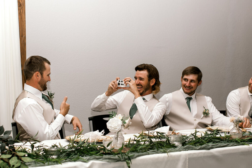 Groomsman snapping a photo with the film camera.