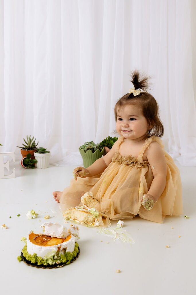 Lubbock photographer, Mary Wiebe, captured this session of a little girlmplaying with her cake during this cake smash session.