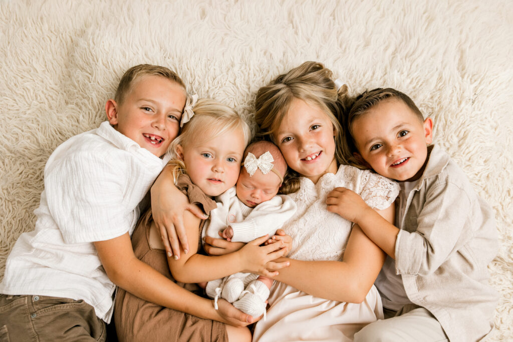 Newborn photography session with baby and four older siblings captured by Mary Wiebe Photography.