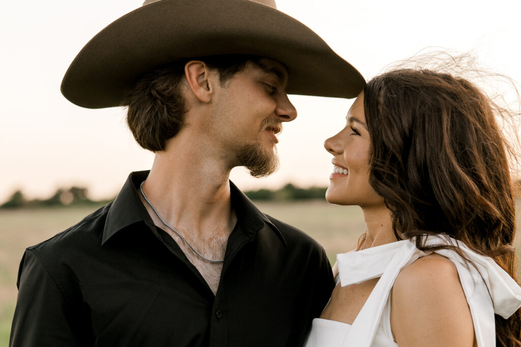 Engagement session captured by Mary Wiebe Photography. Future bride and groom are looking at each other during golden hour in west Texas. If you're looking for the best places to eat in Lubbock Texas for a date night, look no further and enjoy reading this blog. 