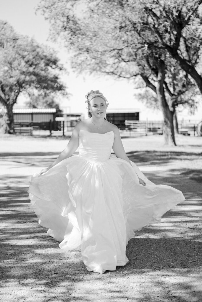 Black and white image of a bride walking down a driveway. Mary Wiebe Photography captured this moment.