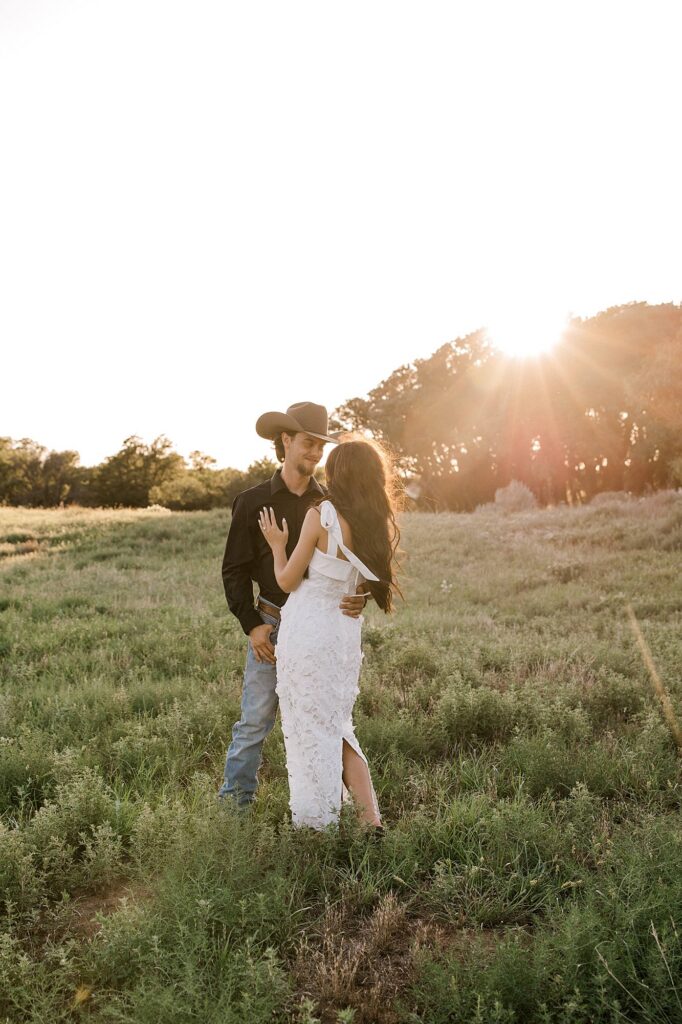 Planning a special thing and need to know the best places to eat in Lubbock Texas for date night? Here Mary Wiebe Photography captures an engagement session where bride and groom are standing in golden hour while she explains the best places to eat. 