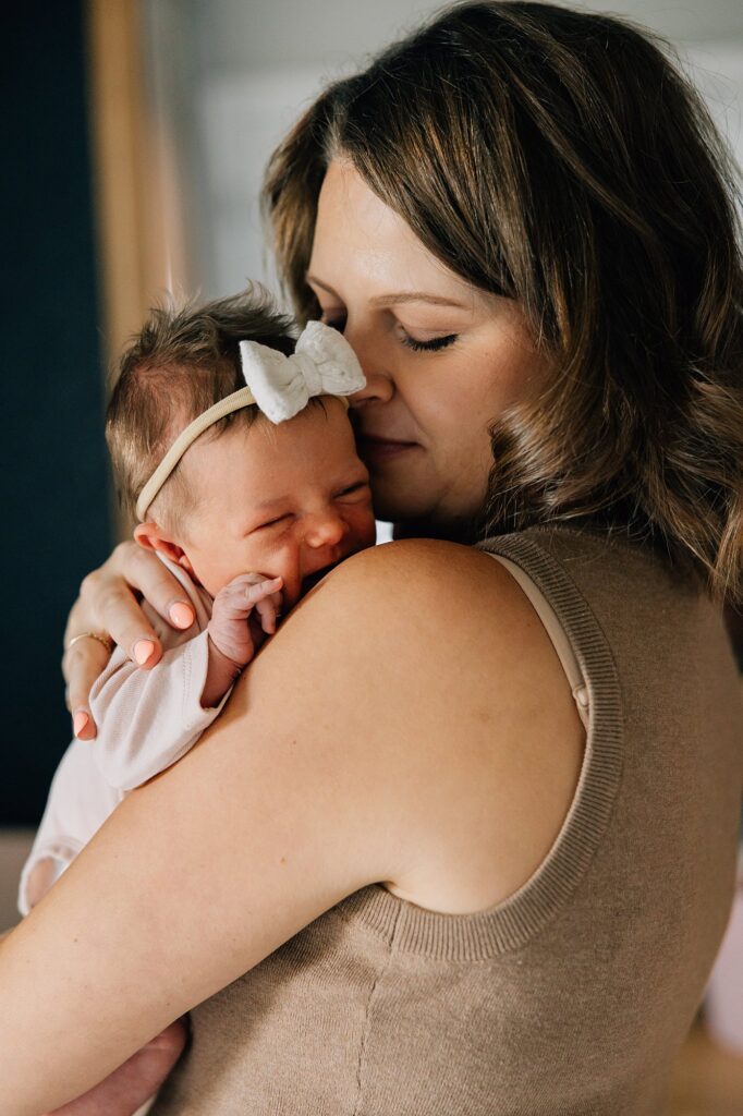 Mom and newborn baby girl are cuddling. 