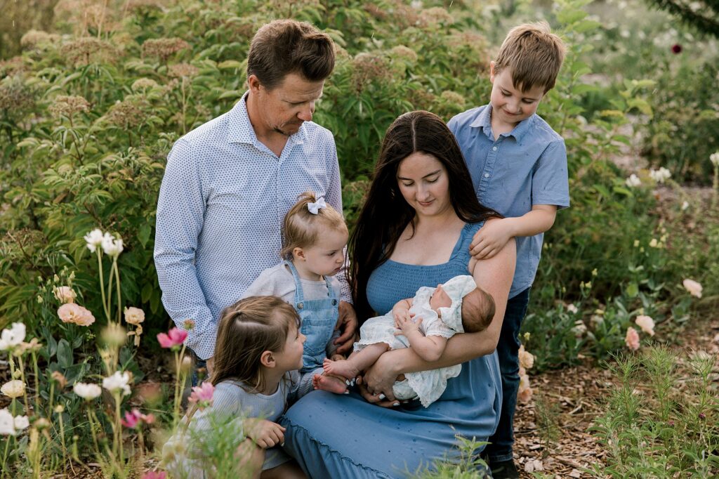 Mom holding baby and father, and three other children are huddled close together.
