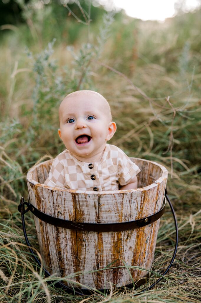 Baby boy sitting in a bucket.