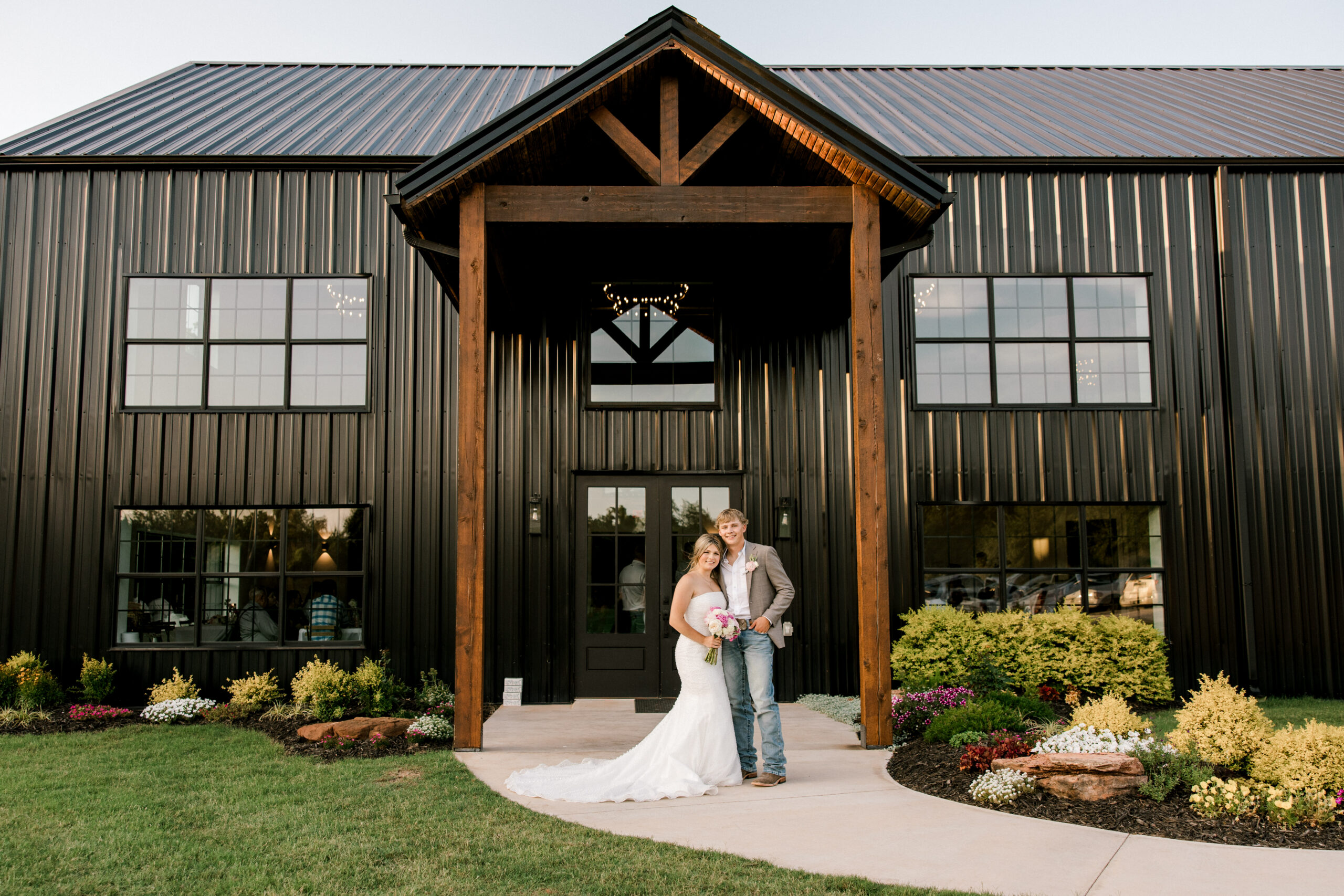 Timber Valley Ranch Wedding Photographer, Mary Wiebe, captured the bride and groom on their wedding day in front of the venue.