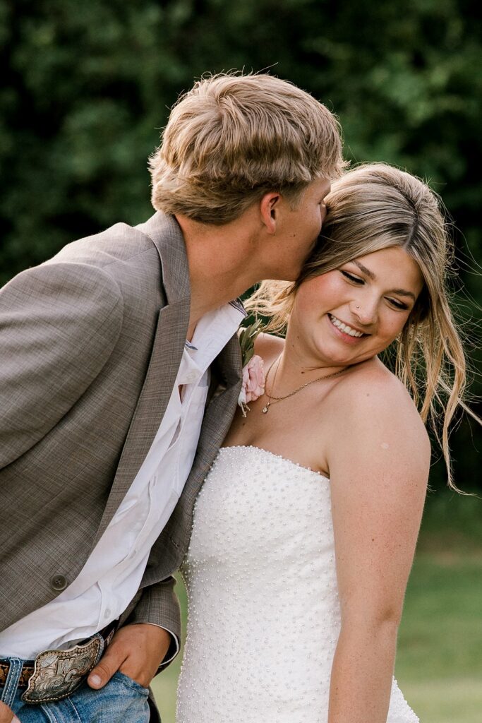 This bride and groom was captured by Mary Wiebe Photography, a Guthrie wedding photographer, standing in a green field.