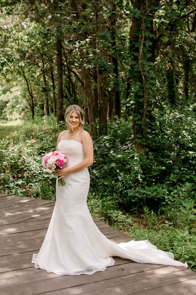 Bridal portraits taken by Timber Valley Ranch wedding photographer, Mary Wiebe. Bride is posing on a bridge.