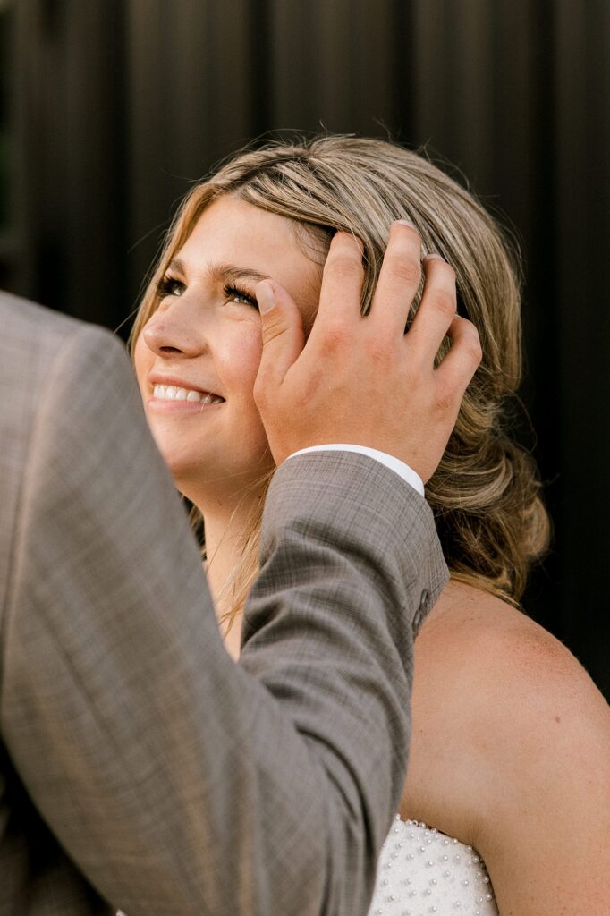 Groom moving his brides hair.