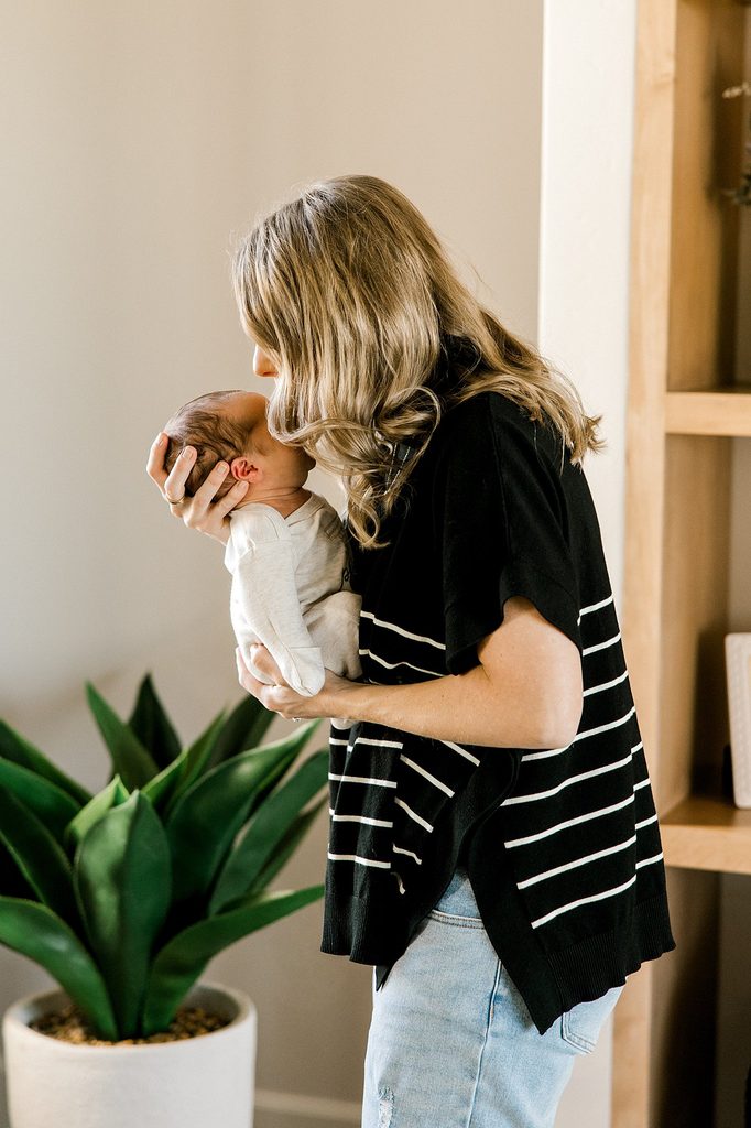 Mom holding her newborn during a lifestyle newborn session in West Texas.