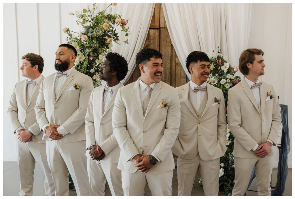 Groomsmen in tan suits with hands folded pose for luxury wedding photos with Mary Wiebe Photography based in Lubbock, TX