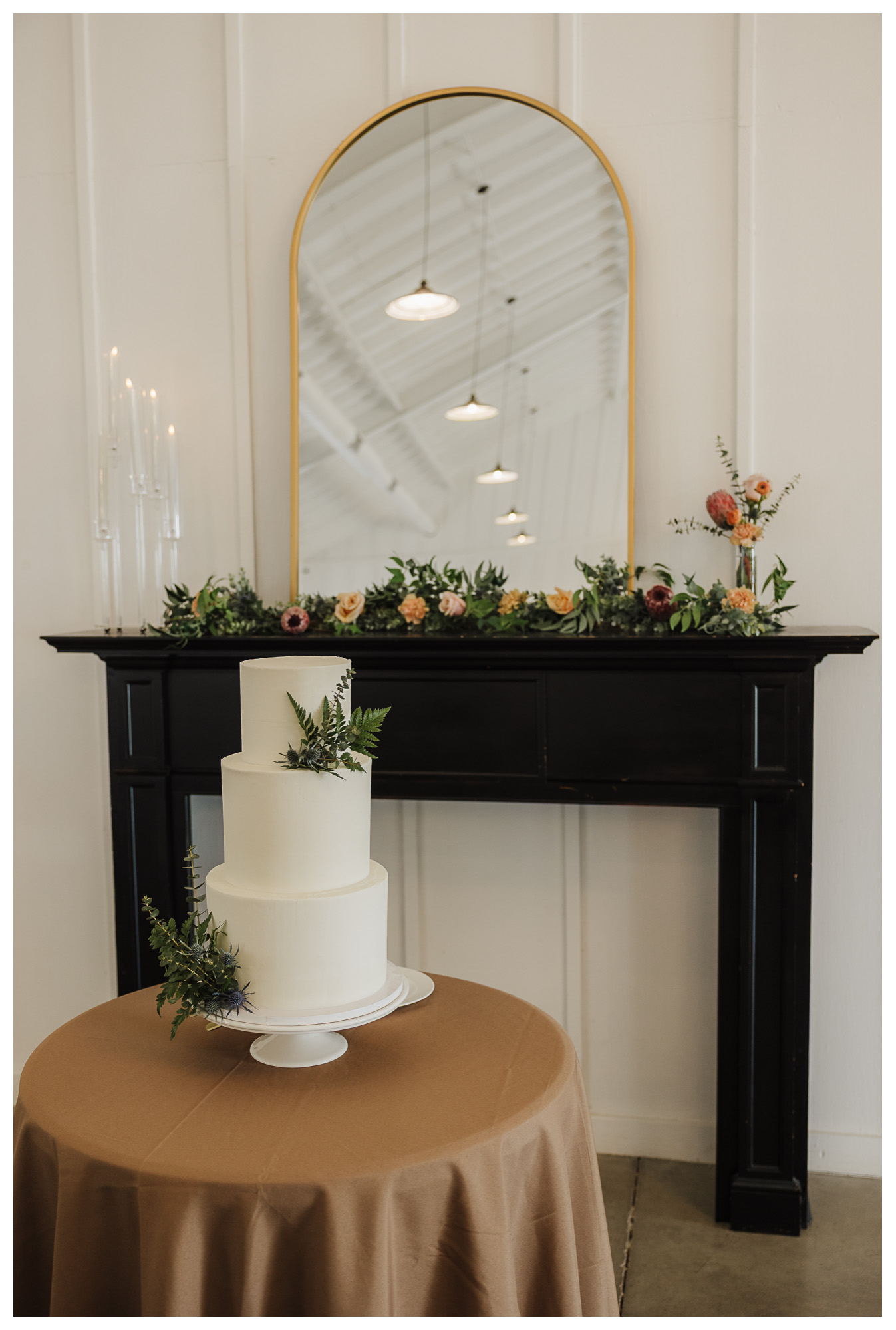 Wedding cake in front of dark brown table topped with flowers and a mirror showcasing wedding color palettes taken by Mary Wiebe Photography based around Lubbock, Seminole, and Denver City, Texas
