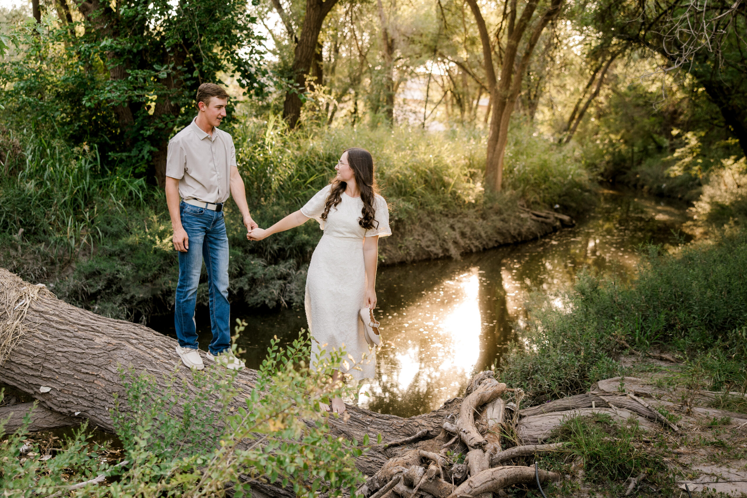 Engaged couple holding hands near a creek Should You Book an Engagement Session? 4 Reasons I Think You’ll Be Glad You Did!
